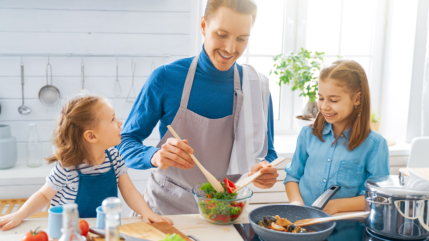Eine Familie bereitet in der Küche eine gesunde Mahlzeit zu.