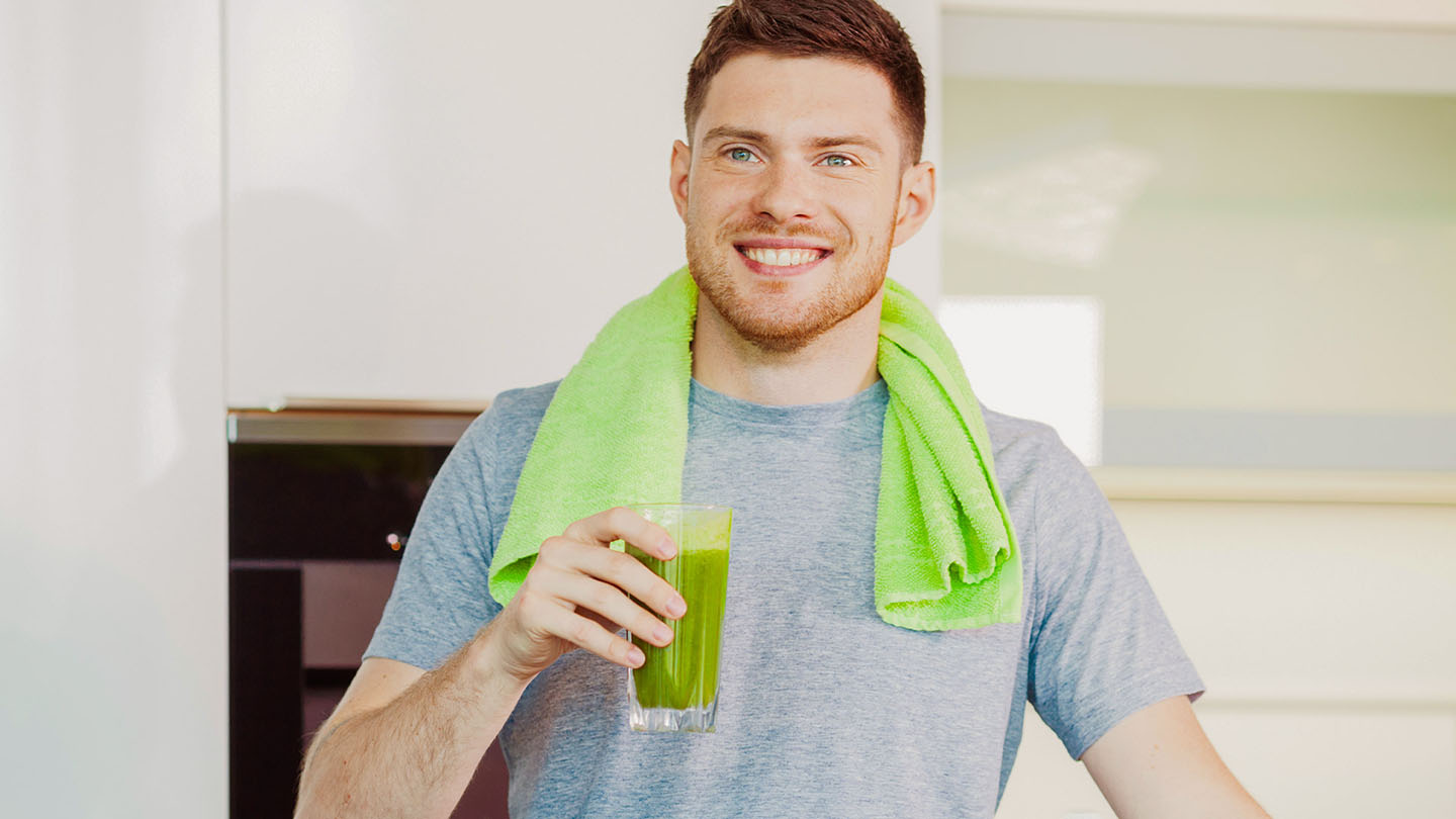 Ein Mann genießt einen gesunden grünen Smoothie.