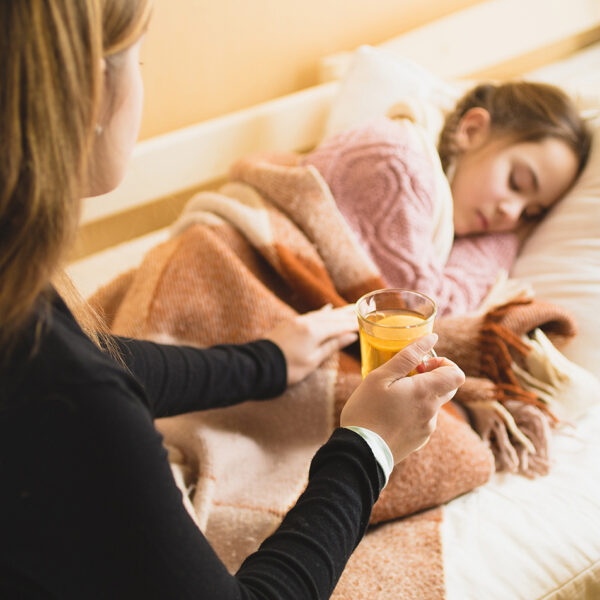 Ein krankes Schulmädchen und ihre Mutter.