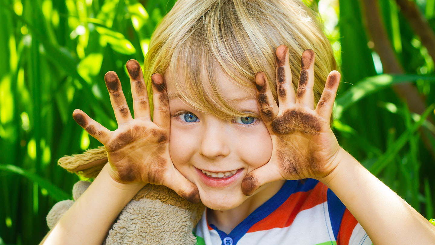 Ein Junge mit schmutzigen Händen.