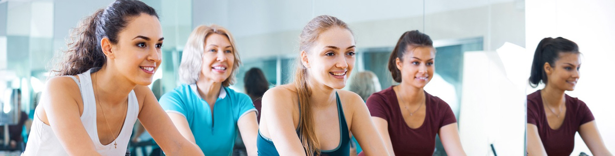 Mlade ženske uživajo v skupinski vadbi.
