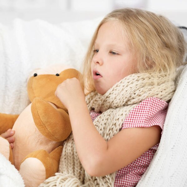 Ein krankes kleines Mädchen klammert sich an ein Stofftier.