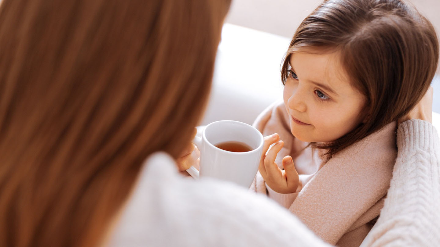 Ein krankes Schulmädchen trinkt Tee.