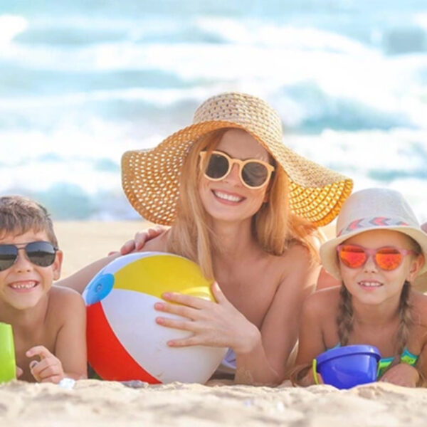 Sommer und Kinderkrankheiten; eine Familie am Meer genießt Strand und Sonne.