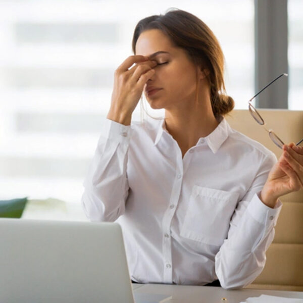 Müde Frau am Schreibtisch im Büro, Stress, Erschöpfung.