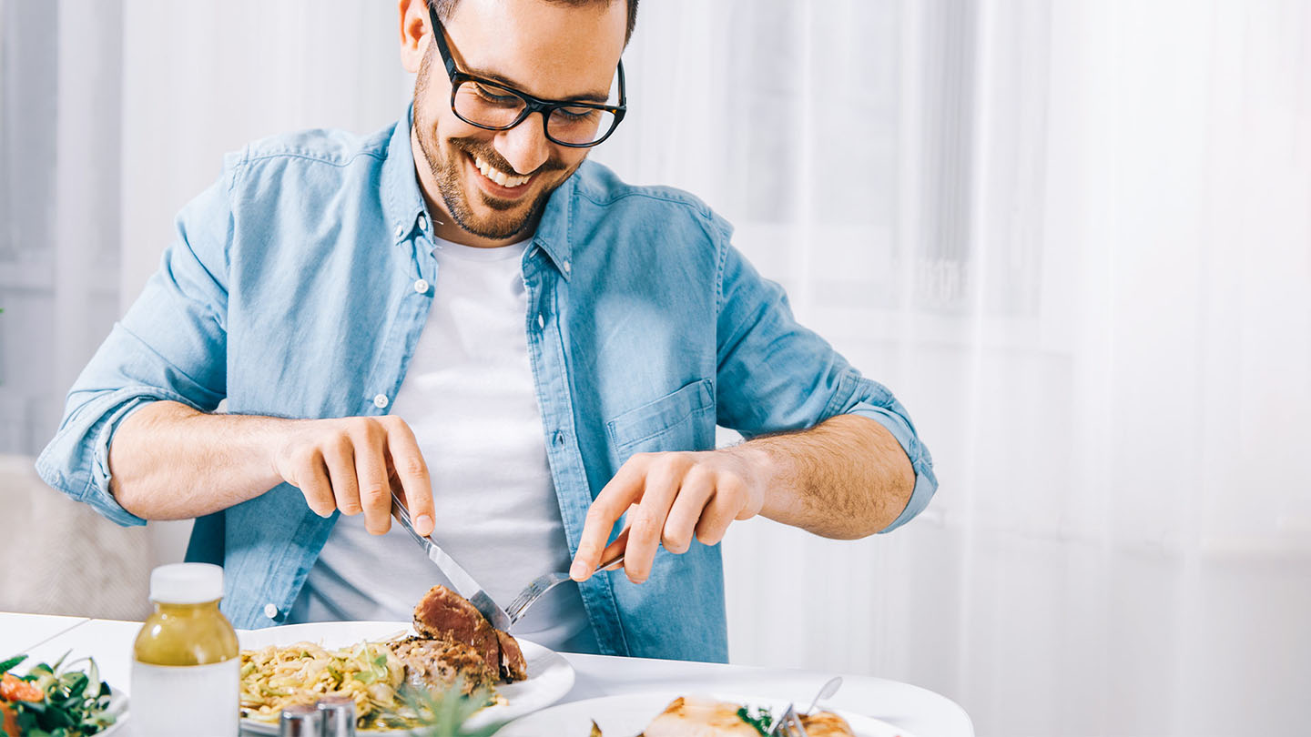 Ein Mann mit einer Erkältung isst leichte Kost.