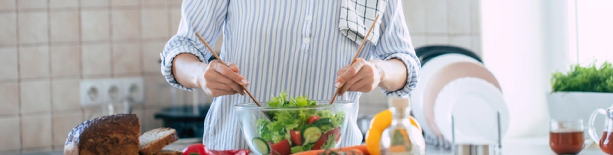 Eine Frau bereitet einen gesunden Salat voller Vitamin C und Zink zu.